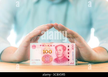Geld sparen. Buchhaltungs-, Geschäfts-, Budget- und Finanzkonzept. Männliche Hände über 100 chinesische Yuan-RMB-Banknote. Stockfoto