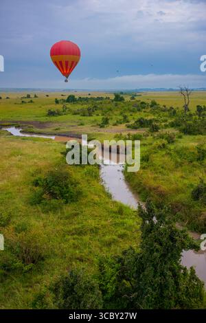 Ein Blick aus der Vogelperspektive auf Heißluftballons, die an einem bewölkten Morgen über der Savanne des Masai Mara National Reserve in Kenia, Afrika, fliegen Stockfoto