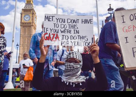 London, England, Großbritannien. August 2025. Ein Demonstrant hält eine Botschaft an die Metropolitan Police, als Polizeibeamte Demonstranten auf dem Parlamentsplatz verhaften, weil sie Plakate zur Unterstützung der Palästinensischen Aktion gehalten haben. Hunderte von Menschen versammelten sich, um Unterstützung für die Aktivistengruppe zu zeigen, die nach dem Anti-Terror-Gesetz verboten ist, und für Palästina. (Kreditbild: © Vuk Valcic/ZUMA Press Wire) NUR REDAKTIONELLE VERWENDUNG! Nicht für kommerzielle ZWECKE! Stockfoto