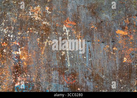Strukturstudie einer lackierten, rostenden Metallwand, orange und blau Stockfoto