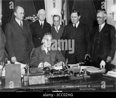 Präsident Franklin D. Roosevelt unterzeichnet das Gold Bill am 30,1934. Januar. Foto: Underwood & Underwood - Franklin D. Roosevelt Presidential Library and Museum. Weitere Informationen: Von links nach rechts: Henry Morgenthau Jr., Eugene R. Black, George F. Warren, Samuel Rosman und James Harvey Rogers nehmen Teil, als Präsident Roosevelt den Gold Reserve Act, 30. Januar 1934 Gold Reserve Act von 1934, unterzeichnet. Stockfoto