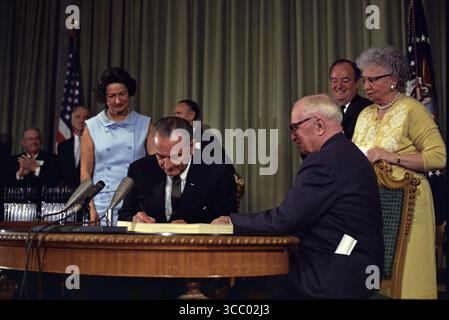 12 32 weitere Details Präsident Lyndon B. Johnson unterzeichnete das Medicare Bill in der Harry S. Truman Library in Independence, Missouri. Der ehemalige Präsident Harry S. Truman sitzt mit Präsident Johnson am Tisch. Stockfoto
