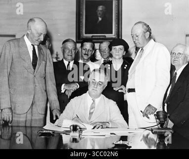 Roosevelt unterzeichnet den Social Security Act: Präsident Roosevelt unterschreibt den Social Security Act, am 14. August 1935 gegen 15:30 Uhr EST. Bei Roosevelt steht Rep. Robert Doughton (D-NC); Stockfoto