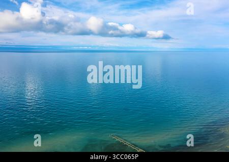 Panoramablick über die Drohne auf den Issyk-Kul-See mit klarem Wasser und blauem Himmel mit Wolken in Kirgisistan. Naturlandschaft von Issyk-Kul in Kirgisisch Republi Stockfoto