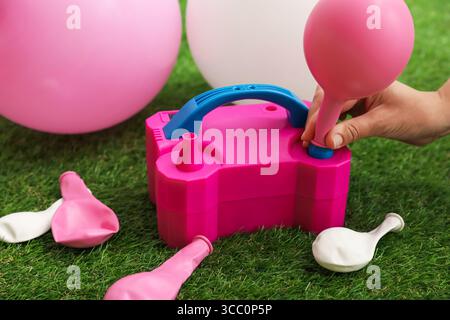Frau, die einen Ballon mit Luftpumpe im Haus aufbläst, Nahaufnahme Stockfoto
