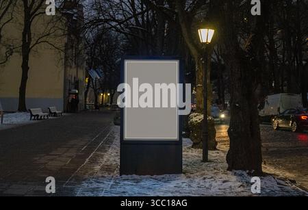 Leere beleuchtete Reklametafeln bei Nacht im verschneiten Stadtpark Stockfoto