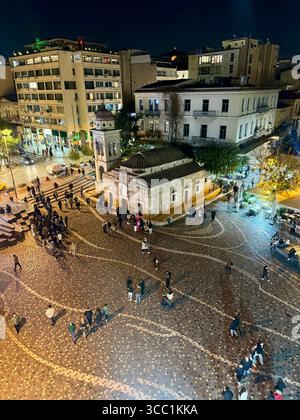 Nächtlicher Blick auf den Monastiraki-Platz in Athen, Griechenland, mit einer alten Kirche, beleuchteten Straßen und Spaziergängen. Stockfoto