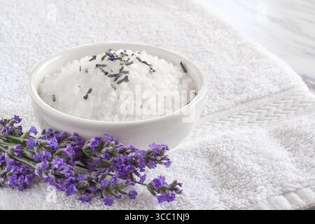 Badesalz mit Lavendelblüten auf weißem Handtuch Stockfoto