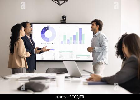 Verschiedene multiethnische Kollegen treffen sich in Gruppen im Besprechungsraum des Büros Stockfoto