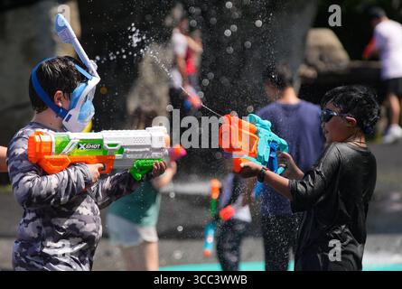 Vancouver, Kanada. August 2025. Kinder necken sich mit Wasserpistolen während des Flash-Mob-ähnlichen Wasserkampfes im Stanley Park in Vancouver, British Columbia, Kanada, am 9. August 2025. Quelle: Liang Sen/Xinhua/Alamy Live News Stockfoto