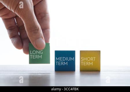Holzwürfel von Hand mit LANGFRISTIGEM Text. Investitionskonzept. Stockfoto
