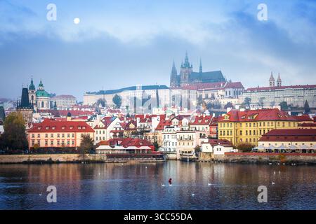 Panoramablick auf Prag mit Karlsbrücke, Moldau und Prager Burg bei Sonnenaufgang, farbenfrohen Wolken und historischer Architektur, die sich auf dem widerspiegelt Stockfoto