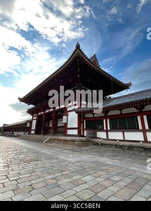 Traditionelles Tempelgebäude im Nara Park, Japan, mit roter und weißer Holzarchitektur unter einem hellblauen Himmel. Stockfoto