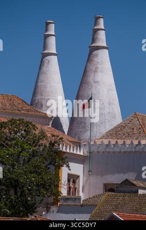 Konische Schornsteine des Nationalpalastes von Sintra über den orange gekachelten Dächern von Sintra, Lissabon, Portugal Stockfoto