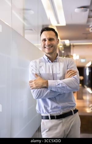 Positiver, selbstbewusster Manager posiert im Bürokorridor Stockfoto