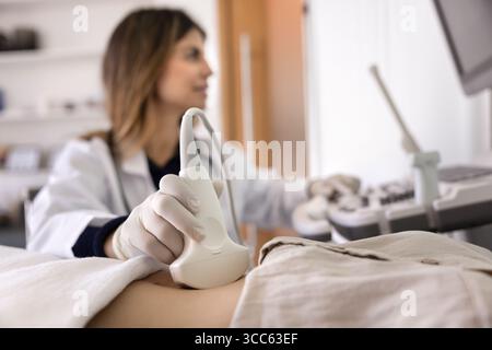 Die Hand des Ultraschalltechnikers, der die Patientin untersucht Stockfoto