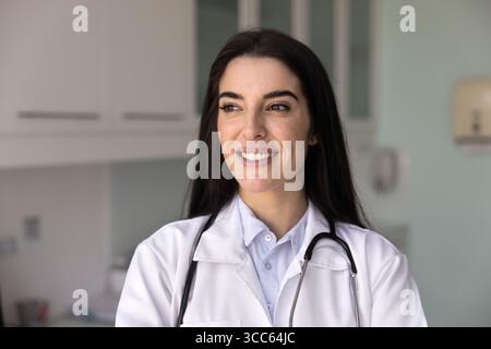 Positive junge hispanische Gesundheitsarbeiterin posiert für ehrliches Porträt Stockfoto