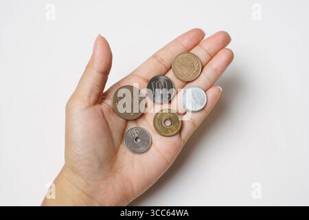 Isolierte Hand Hold Money Japanische Münze. Wechselkurs 500, 100, 50, 10, 5 und 1 Yen. Stockfoto