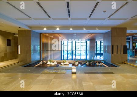 Eine geräumige und elegante Lobby mit moderner Architektur, Natursteinfliesen und minimalistischer Dekoration im Four Seasons Hotel Kyoto. Die große Stockfoto
