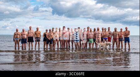 Portobello Beach, Edinburgh, Schottland, Großbritannien, 10. August 2025. Edinburgh Festival Fringe: Australischer Musicaltheaterstar Darby James und die einheimische Gruppe für Männer im Freien, die Edinburgh Blue Balls, schwimmen am Sonntagmorgen im Firth of Forth. Quelle: Sally Anderson/Alamy Live News Stockfoto