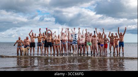 Portobello Beach, Edinburgh, Schottland, Großbritannien, 10. August 2025. Edinburgh Festival Fringe: Australischer Musicaltheaterstar Darby James und die einheimische Gruppe für Männer im Freien, die Edinburgh Blue Balls, schwimmen am Sonntagmorgen im Firth of Forth. Quelle: Sally Anderson/Alamy Live News Stockfoto