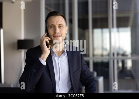 Selbstbewusster, gutaussehender lateinischer Geschäftsmann, der auf dem Handy spricht Stockfoto