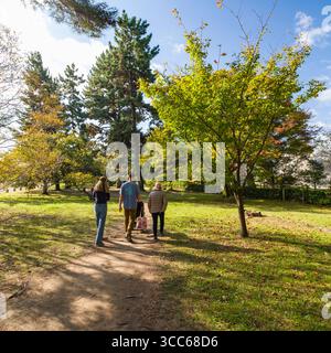 Eine Familie macht einen gemütlichen Spaziergang an einem sonnigen Tag im Kyoto Gyoen National Garden. Die Umgebung vermittelt Ruhe, Verbindung und die Schönheit der Natur Stockfoto