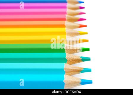 Bunte, geschärfte Holzstifte in Reihe angeordnet, isoliert auf weißem Hintergrund mit Kopierraum. Nahaufnahme, Makro. Helles, lebendiges Schreibwarenkonzept f Stockfoto