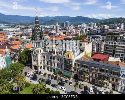 Stadtblick mit beeindruckenden, historisch inspirierten Gebäuden vor einem Bergpanorama, Luftsicht, astronomische Uhr, Black-Gold-Dach, Europe S Stockfoto