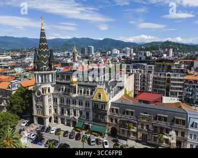 Charmante Stadt mit historischer Architektur vor der Kulisse der Berge und des blauen Himmels, Blick aus der Luft, astronomische Uhr, Black Gold Roof, Europe Square Stockfoto