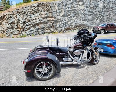 Schwarzes Harley-Davidson-Motorrad mit drei Rädern, geparkt an einer Bergstraße; CSC California Side Car Stockfoto