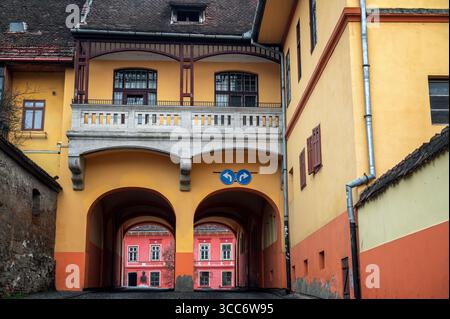 Farbenfrohe gelbe, orange und rosafarbene Architektur auf mittelalterlichen Gebäuden im historischen Sighisoara, Bulgarien Stockfoto