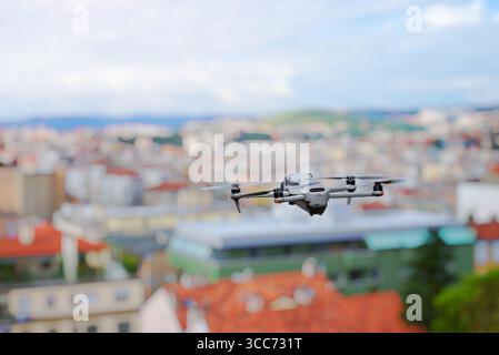 Rückansicht der Drohne, die bei Tageslicht über Stadtgebäude fliegt Stockfoto
