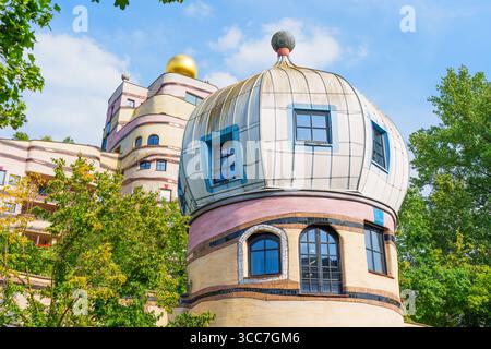 Aus nächster Nähe sehen Sie einzigartige architektonische Merkmale des Wohnkomplexes Waldspirale, die farbenfrohe Fassade und skurrile Designelemente hervorheben. Stockfoto