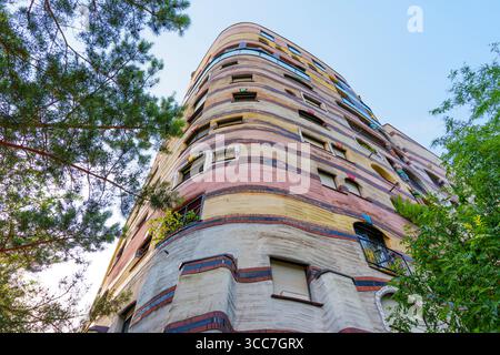 Geschwungene Fassade des Wohnkomplexes Waldspirale mit bunten Streifen und einzigartigem architektonischen Design, umgeben von Grün in Darmstadt, Deutschland Stockfoto