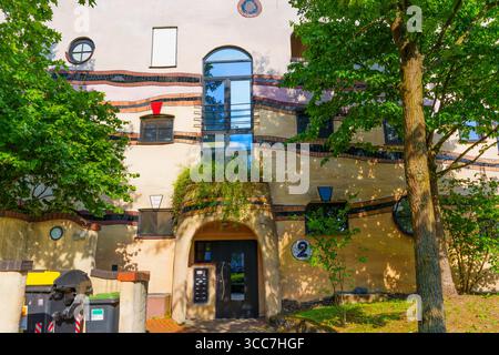 Darmstadt, Deutschland - 18. Juni 2025: Farbenfrohe Fassade des Wohnkomplexes Waldspirale mit einzigartigen architektonischen Elementen, umgeben von üppigem Grün Stockfoto