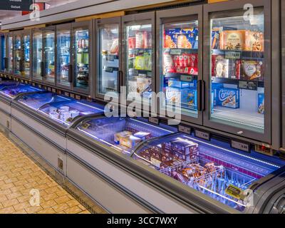Italien - 31. Juli 2025: Verschiedene Arten und Marken von verpacktem Eis auf einer Theke und in einem gekühlten Vitrinenschrank zum Verkauf in einem Italiener Stockfoto