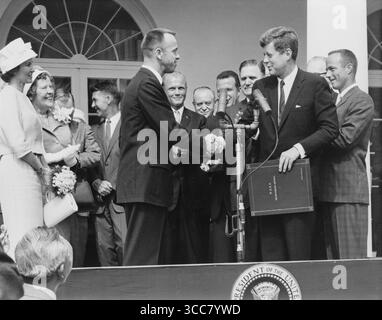 - Astronaut Alan B. Shepard Jr. erhält den NASA Distinguished Service Award vom US-Präsidenten John F. Kennedy am 8. Mai 1961, Tage nach seiner Geschichte, als er MR-3-Flug machte. Shepards Frau und Mutter links und die anderen sechs Mercury-Astronauten sind im Hintergrund. Stockfoto