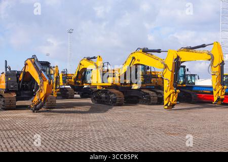 Neue gelbe Raupenbagger werden auf der Baustelle geparkt. Stockfoto