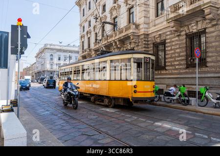 Alte gelbe italienische Straßenbahn und Fahrrad. Straßenbahnlinie auf der Straße. Italien, Mailand - 17. Juli 2025 Stockfoto
