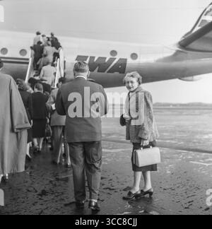 Vintage 1952 Schwarzweiß-Foto, das eine Gruppe von Personen zeigt, die an Bord eines Flugzeugs der TWA, Trans World Airlines, Lockheed Constellation sind. Stockfoto