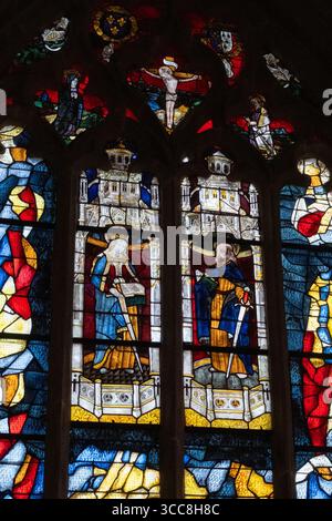 Detail des Ostfensters der Kapelle mit zwei Charakteren mit Schwertern und einem Kreuz um sie herum, Licht kommt von hinten im Freien Stockfoto