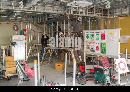 Bauarbeiter, die an Metallrahmen in neuen Einzelhandelsräumen arbeiten, Cat Street, Jingumae, Shibuya City, Tokio, Kantō, Honshu, Japan Stockfoto
