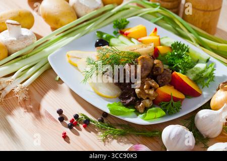 Salat mit Hühnerherzen, Pfirsichen, Birnen Stockfoto