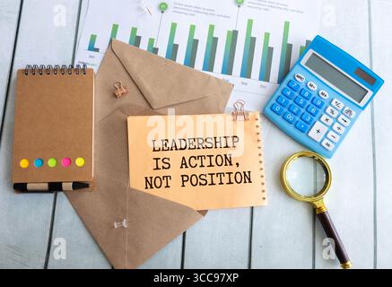 Die Führung des Bildsatzes in der Draufsicht ist eine Aktion, nicht die Position, die auf dem Notizbuch mit einem Stift auf dem Tisch geschrieben ist. Stockfoto