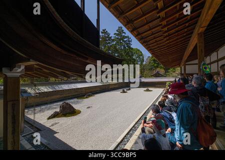 Besucher sitzen und genießen den Blick auf den Garten Ryoan-JI Hojo Teien Kare-sansui Zen im buddhistischen Tempel Ryōan-JI, Ryoanji Goryonoshitacho, Ukyo Ward, Stockfoto
