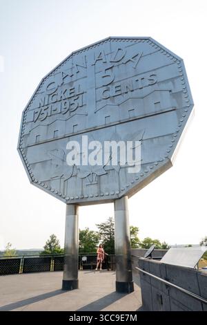 Sudbury, Kanada. August 2025. Touristen besuchen das Big Nickel Display im Dynamic Earth Science Museum. Der Big Nickel in Sudbury, Ontario, ist eine 9 Meter lange Nachbildung eines kanadischen Nickels aus dem Jahr 1951 im Dynamic Earth Science Museum als Hommage an das Bergbauerbe der Stadt. Die 1964 erbaute Münze ist die weltweit größte Münze und ein beliebter Ort für Fotos. Quelle: SOPA Images Limited/Alamy Live News Stockfoto