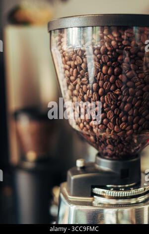 Nahaufnahme der Kaffeebohnen im Grinder Hopper im Coffee Shop Stockfoto