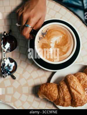Lavendellatte und Croissant auf Café-Tisch Stockfoto