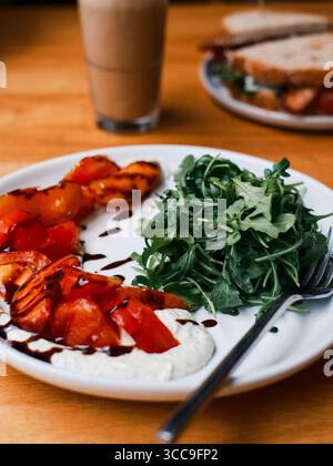 Rucola-Salat und Tomaten mit cremiger Basis, Fork Detail Stockfoto